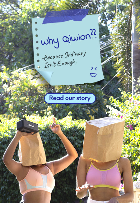 Two people with paper bags over their heads, one holding a sign with text, against a blurred outdoor background.