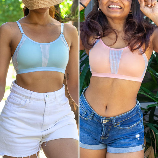 A side by side comparison of two Qiwion BAE bras in mint whip or light blue and tanglow (light pink). the bras have mesh for better breathability