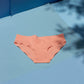 Peach-colored underwear on a blue surface