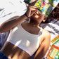 Person holding a magazine, lying down in a qiwion jumpstart bra in a light cream colour, with a pair of shorts.