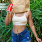 Person holding a Coca-Cola can with a paper bag over their head outdoors, wearing a qiwion jumpstart bra in cream colour, with a pair of shorts. 