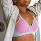 A woman wearing a Qiwion bra in pink and blue with a light grey jacket.