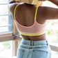 Person wearing Qiwion Mood bra in a light pink colour, mesh back, no hooks and neon straps and underband