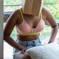 Person wearing a light pink bra with neon underband and straps. Combed cotton bras suited for girls