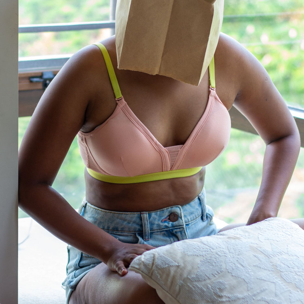 Person wearing a light pink bra with neon underband and straps. Combed cotton bras suited for girls