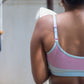 Person wearing a pink and light blue Qiwion bra, with adjustable straps -  with a blurred background