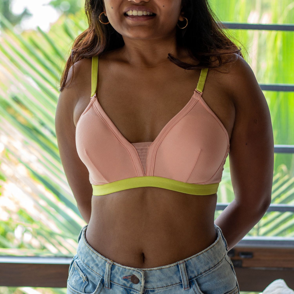 Person wearing a light pink bra with neon underband and straps. Combed cotton bras suited for girls