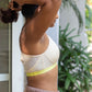 Woman wearing Qiwion Mood bra in cream and neon shades. Side profile showing seams and mesh back detailing