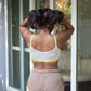 Person wearing Qiwion mood bra in light cream, with neon straps and mesh back. 