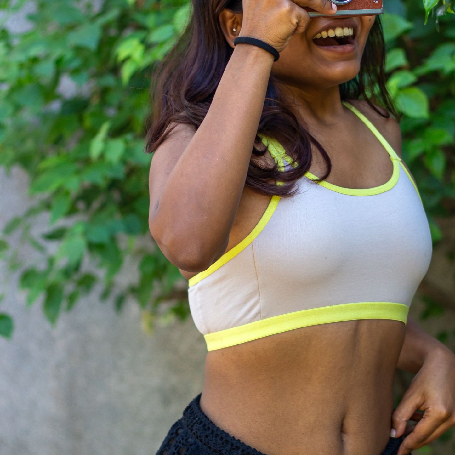 Person wearing a light grey and neon qiwion jumpstart bra in the outdoors