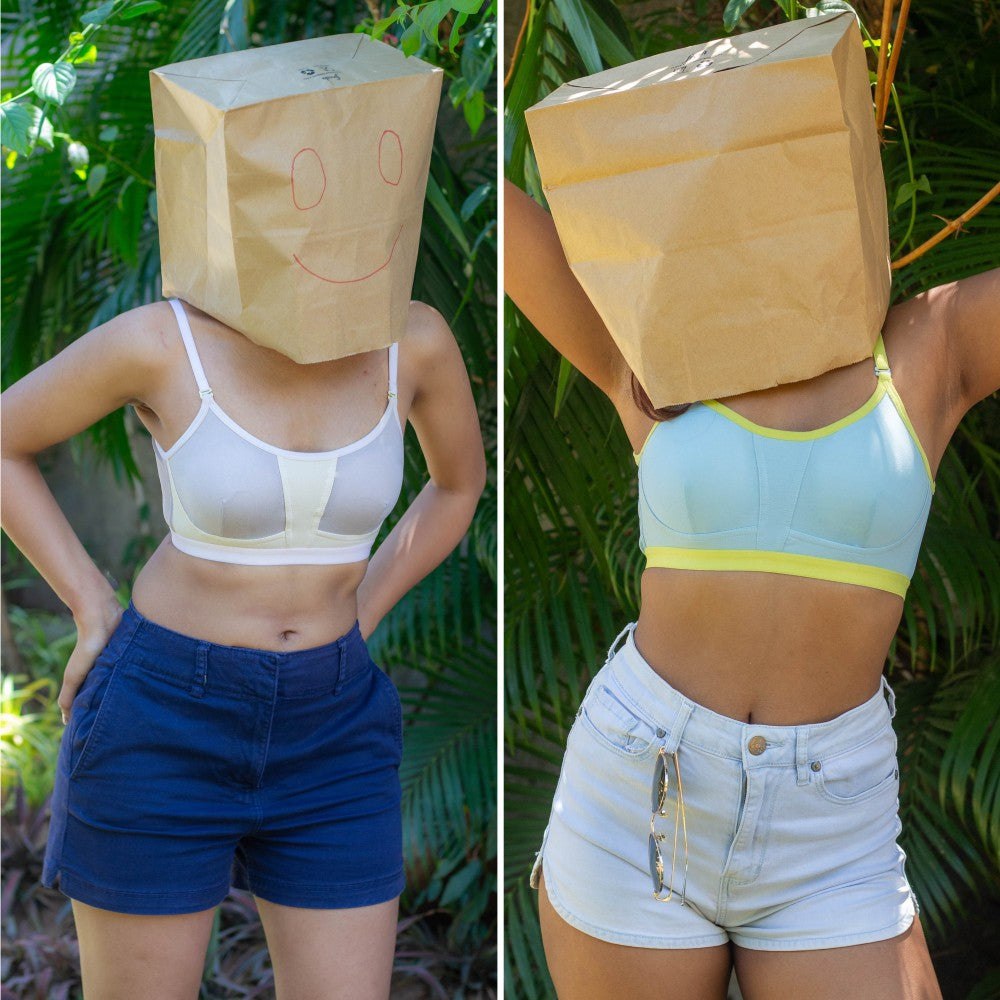 Two images of a person wearing a brown paper bag over their head with a smiley face, one in a white bra and blue shorts, the other in a light blue sports bra and white shorts, against a green leafy background.