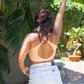 Woman showing her back, wearing a qiwion one and done bra with the straps criss cross, paired with denims
